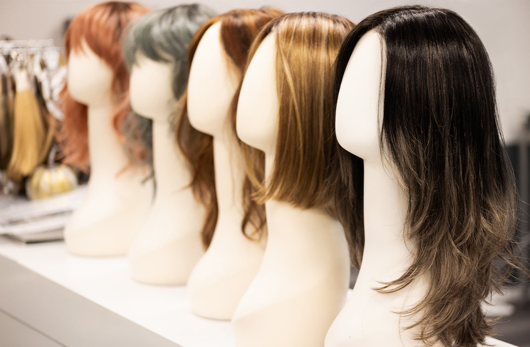 Synthetic wigs sitting on wig stands